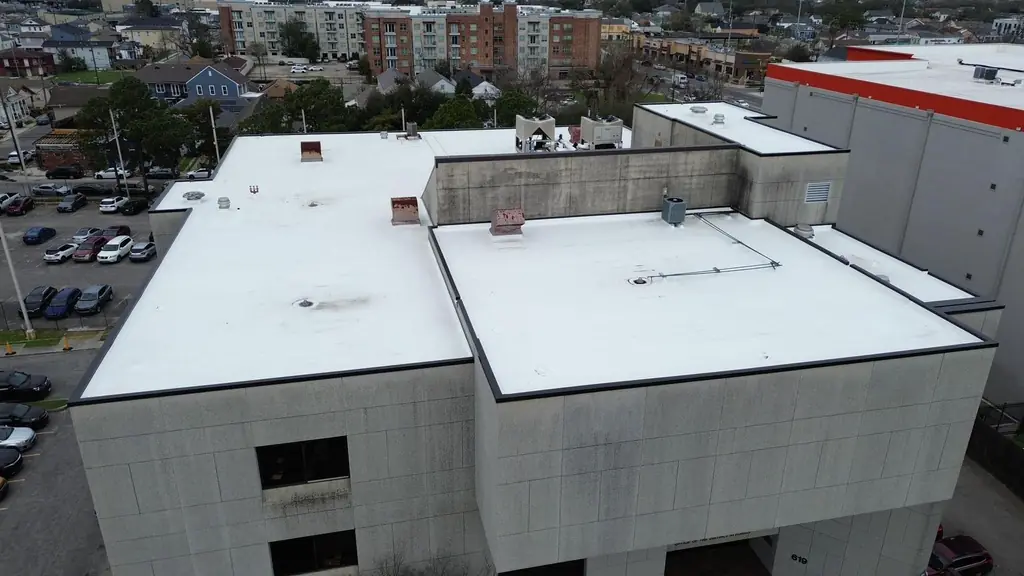 Completed white flat TPO roof on a multi-storey commercial building, seen from the air