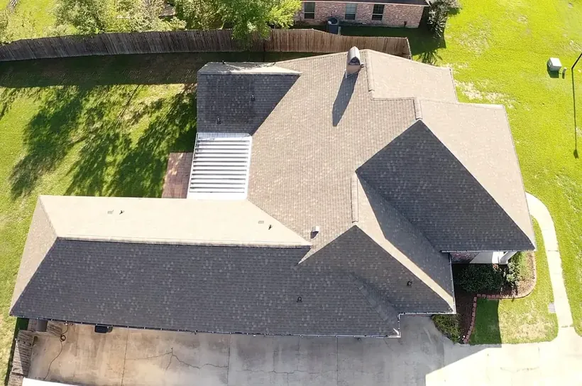 Aerial view of a home with a complex multi-gable roofline, newly finished