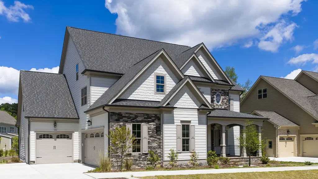 A finished two-storey new-construction home with stone accents and a complete new roof